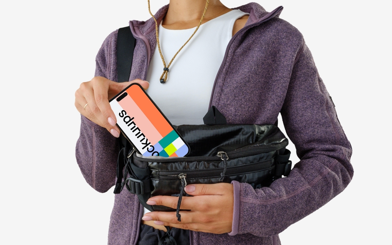 Female tourist holding iPhone mockup with transparent background, device mockup generator template showing reliable grip