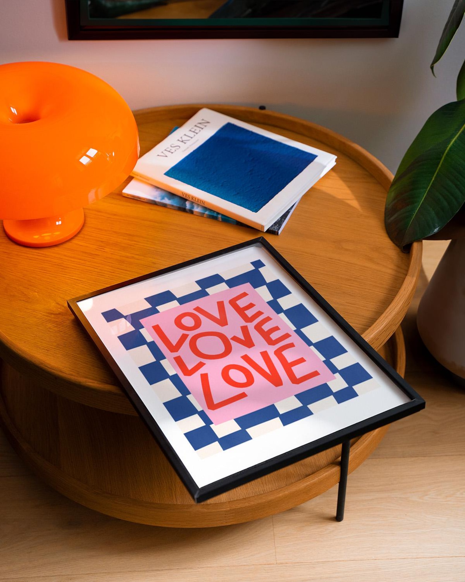 Framed graphic print with playful typography on a sleek table, perfect for best poster mockups in a cozy, artistic setting.