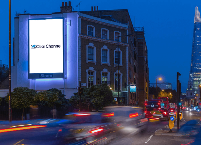 Brightly lit digital billboard on a London building at night