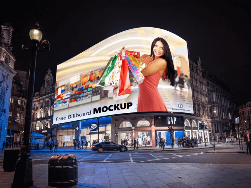 Curved digital billboard in a London shopping district at night