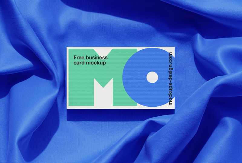 Free EU business card mockup on blue fabric. Ideal for showcasing professional designs.