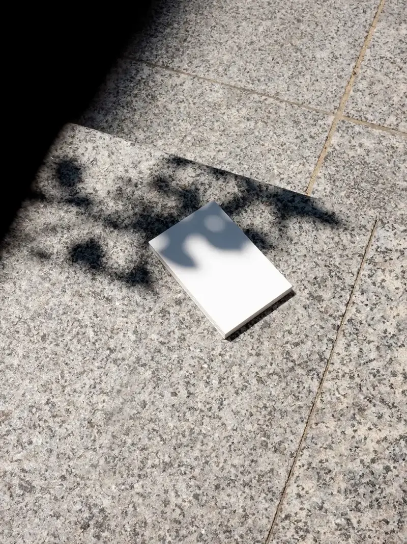 EU business card mockup on granite surface with shadows, ideal for showcasing designs using a business card mockup generator.